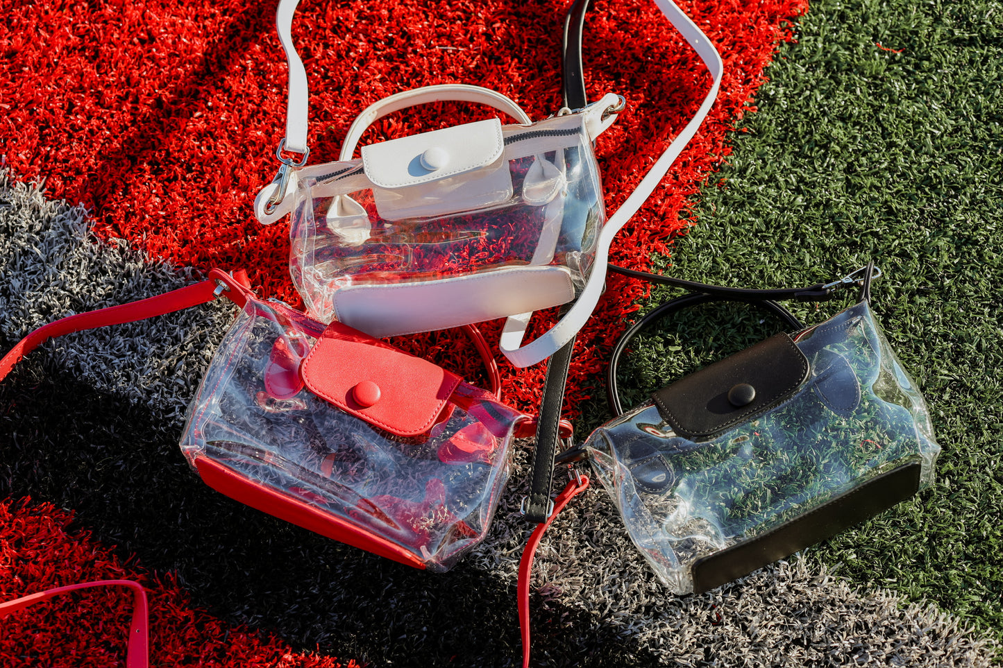 Clear and transparent bags with colorful accents on a football field.