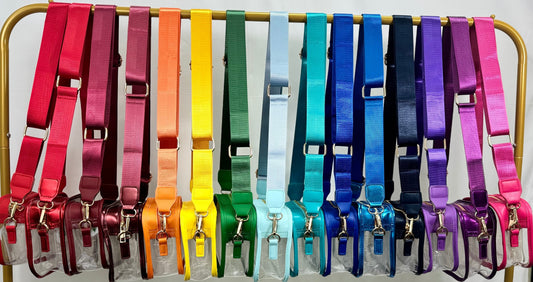 Set of colorful clear stadium purses on a stand against a white background
