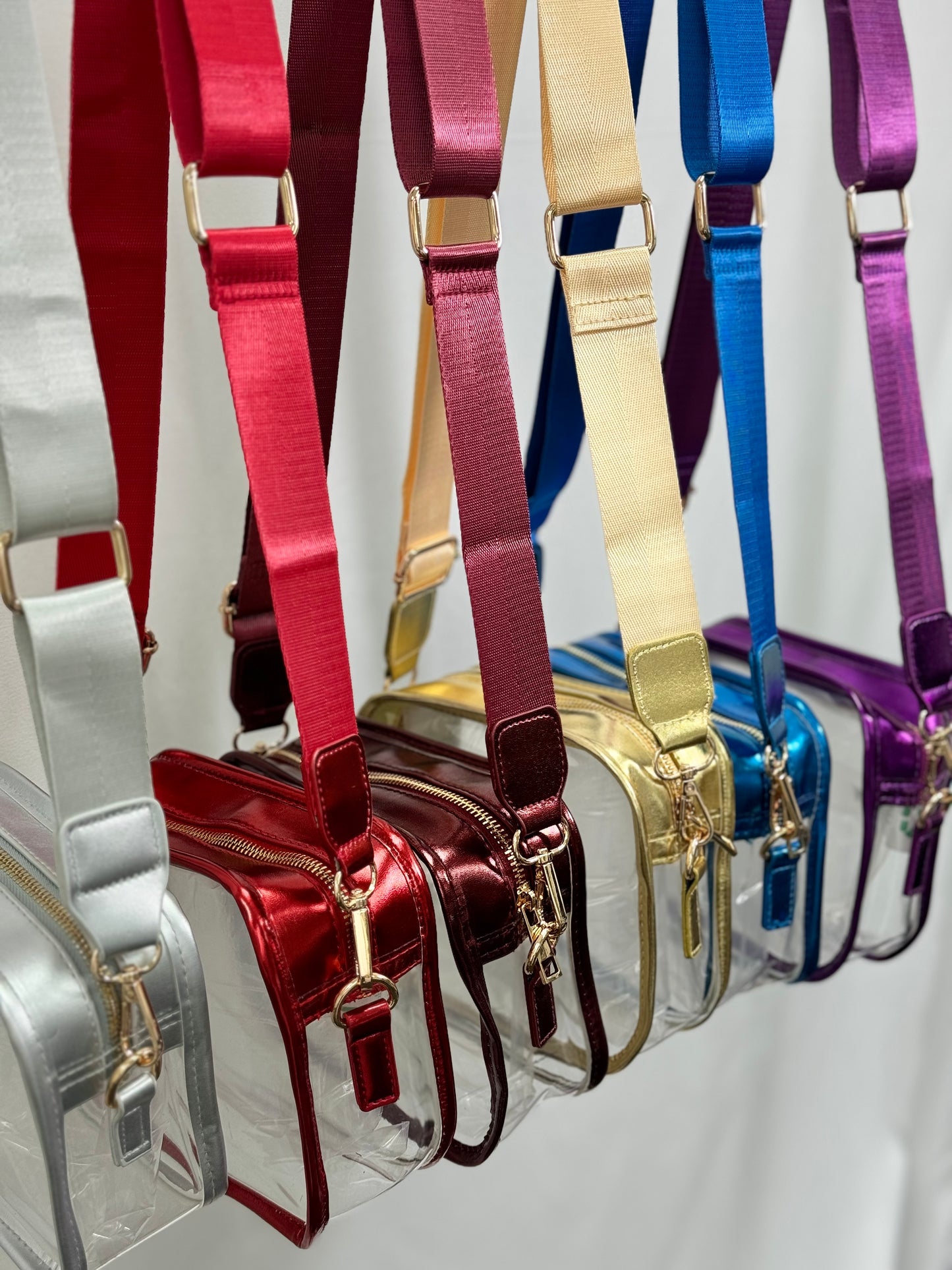 Collection of colorful handbags with matching straps on a white background